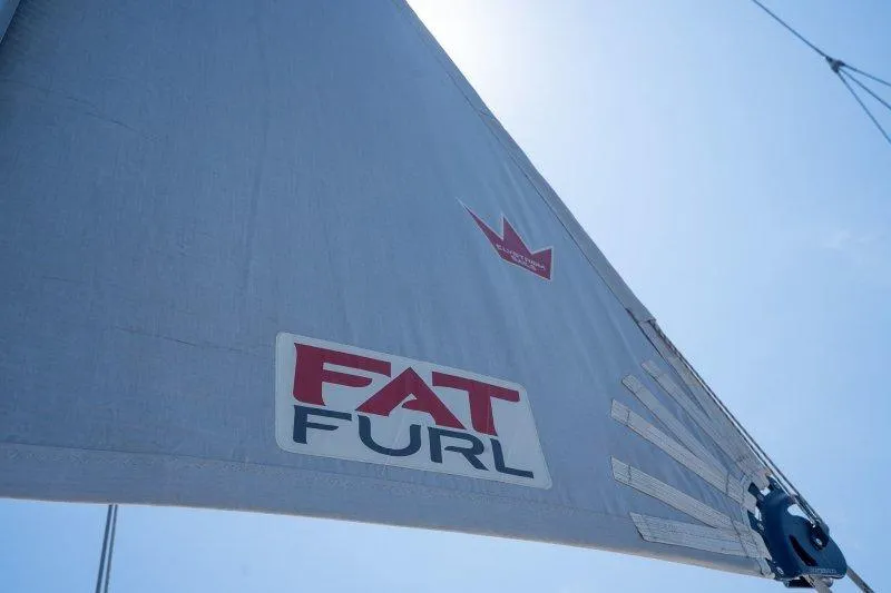  Yacht Photos Pics Sail of 2023 Hallberg-Rassy 50 yacht with "FAT FURL" branding against blue sky.