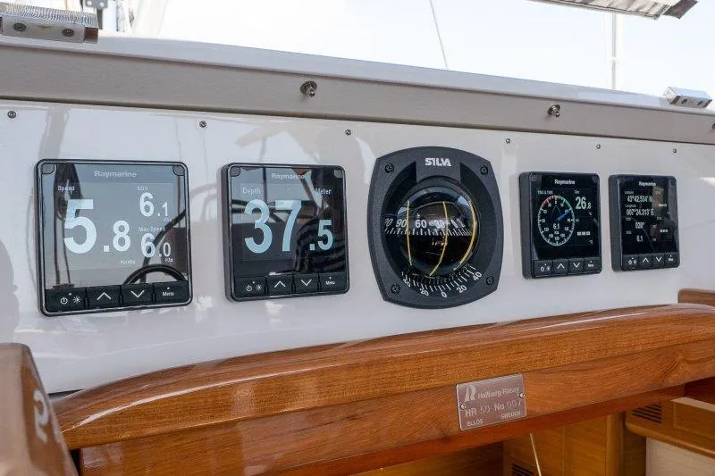  Yacht Photos Pics Control panel of 2023 Hallberg-Rassy 50 yacht with navigation instruments and displays.