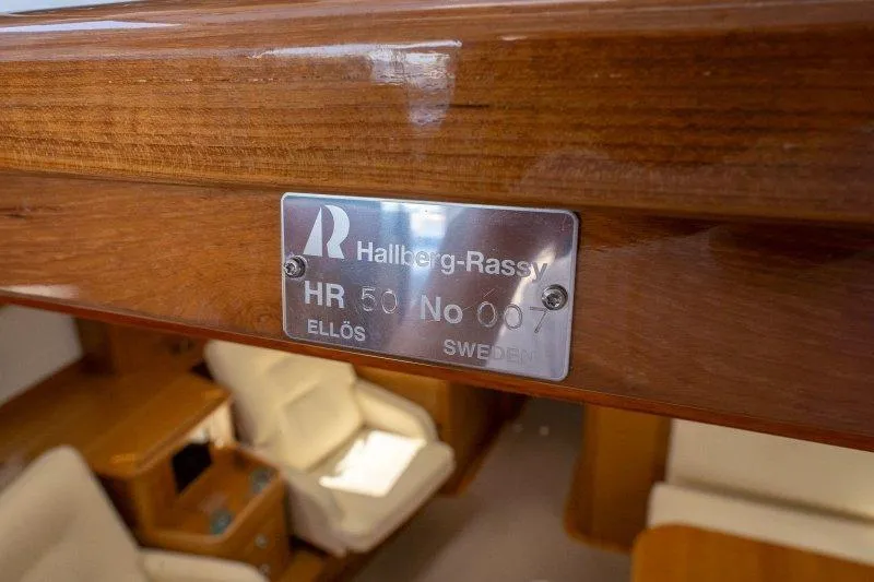  Yacht Photos Pics Plaque on 2023 Hallberg-Rassy 50 yacht, displaying model and serial number in elegant interior.