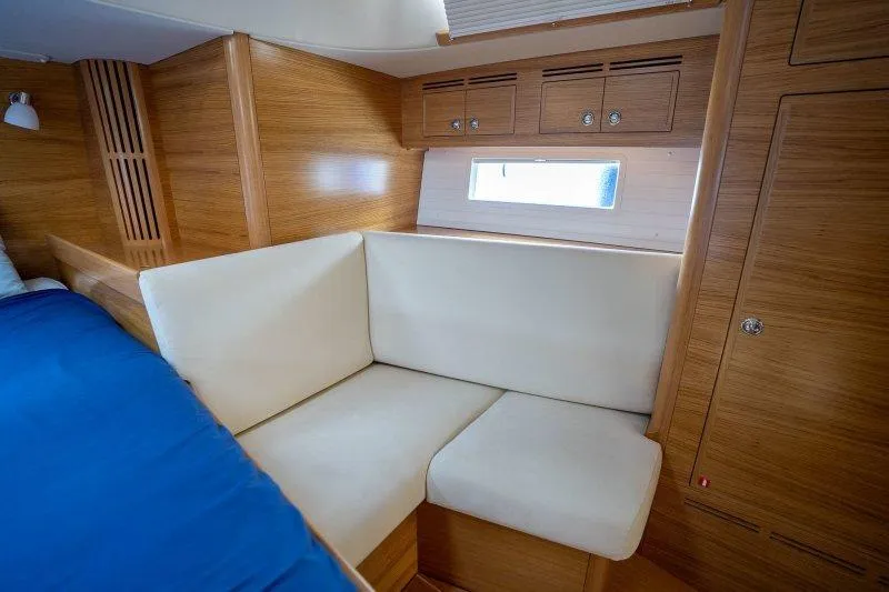  Yacht Photos Pics Interior of 2023 Hallberg-Rassy 50 yacht with cozy seating and wooden finish.