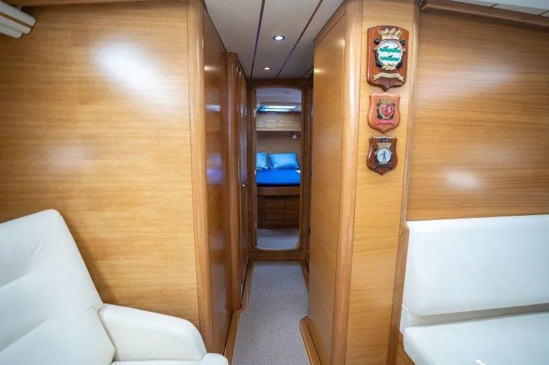  Yacht Photos Pics Luxurious interior of 2023 Hallberg-Rassy 50 yacht with wood paneling and cozy cabin.