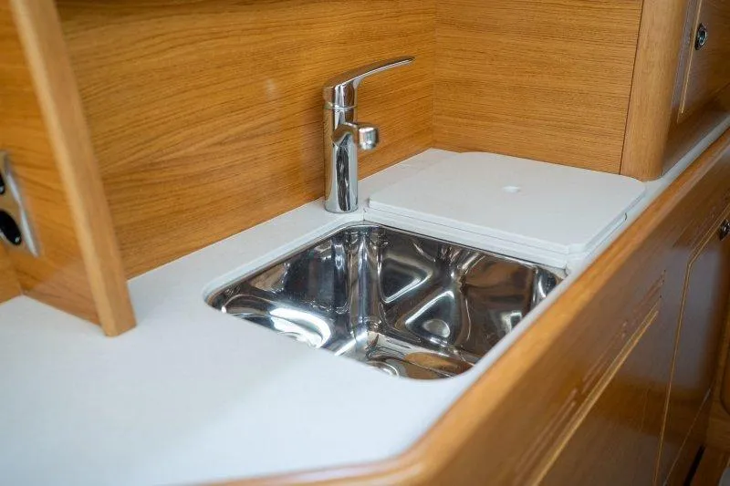  Yacht Photos Pics Modern sink in 2023 Hallberg-Rassy 50 yacht with wooden cabinetry.