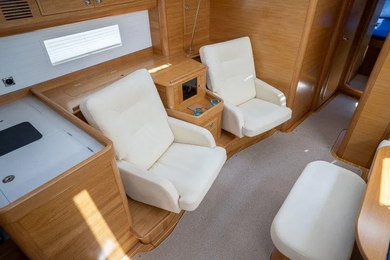  Yacht Photos Pics Luxurious 2023 Hallberg-Rassy 50 yacht interior with plush seating and elegant wood finish.