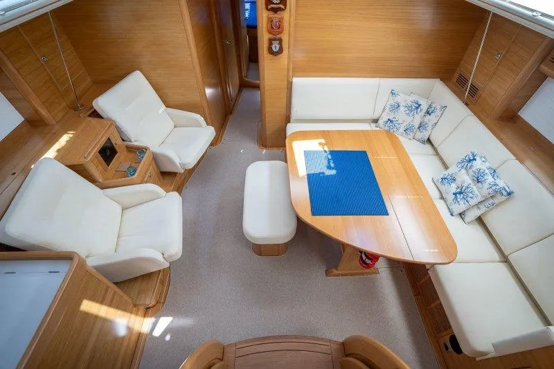  Yacht Photos Pics Luxurious 2023 Hallberg-Rassy 50 yacht interior with elegant seating and wooden finishes.