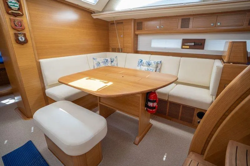  Yacht Photos Pics Luxurious interior of 2023 Hallberg-Rassy 50 yacht with elegant seating and wooden table.