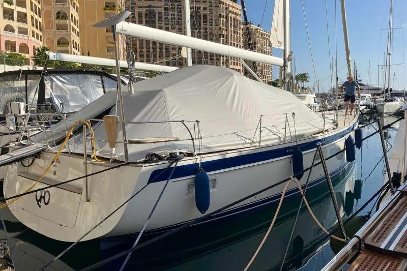  Yacht Photos Pics 2023 Hallberg-Rassy 50 yacht docked in marina, covered and secured with ropes.