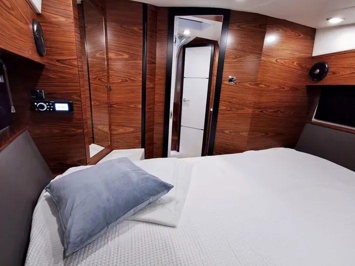  Yacht Photos Pics Luxurious interior of 2025 Cobrey 33 HT yacht with wood paneling and cozy bedding.
