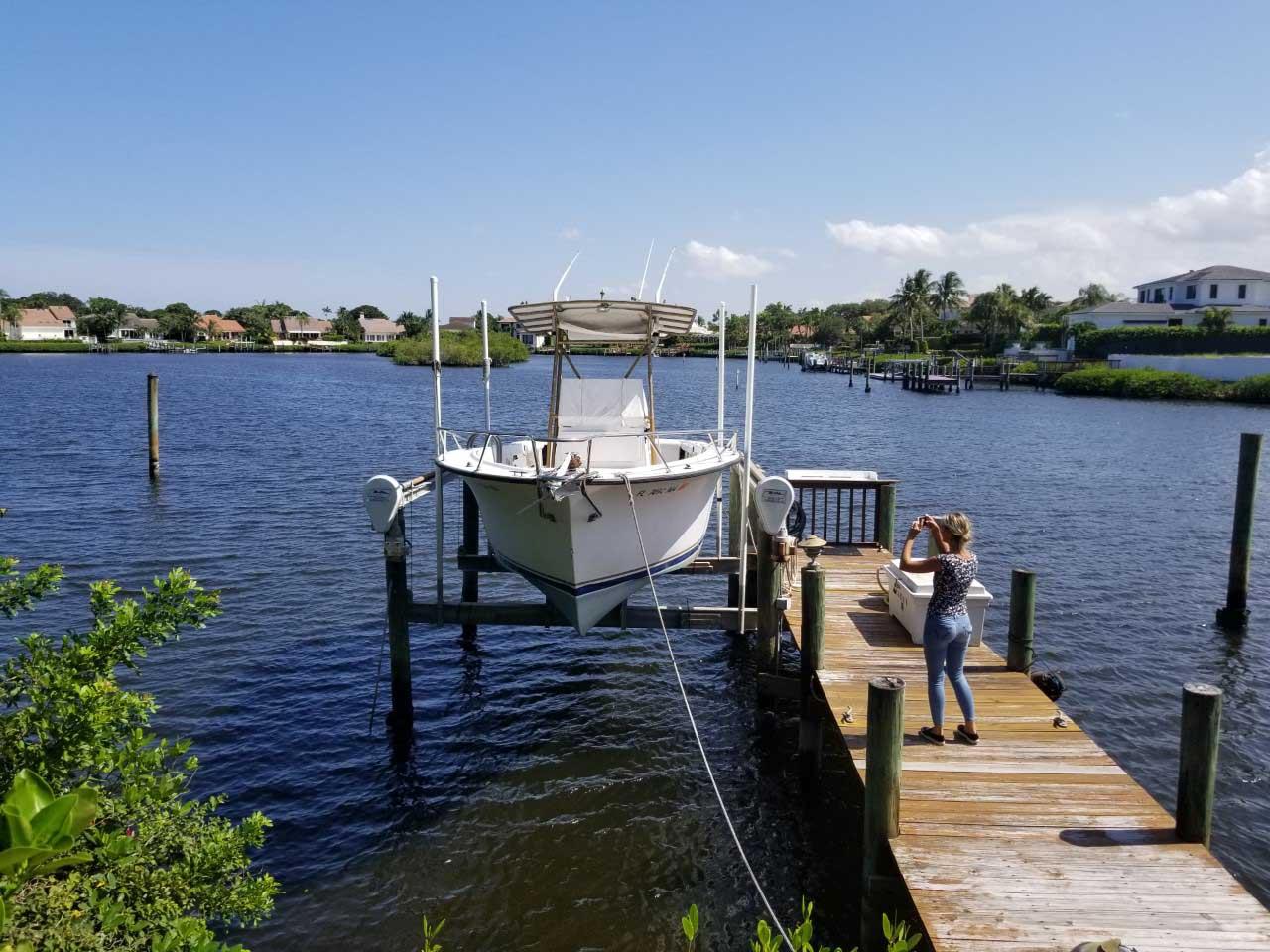 A 1977 Pace Wahoo boat docked on a sunny day, with a person taking photos.