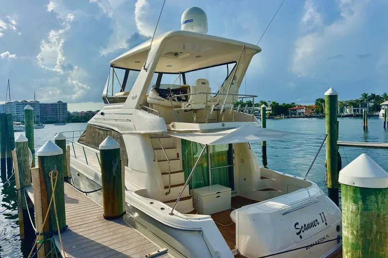 Scanner II Yacht Photos Pics 1998 Sea Ray 480 Sedan Bridge yacht docked at marina under cloudy sky.