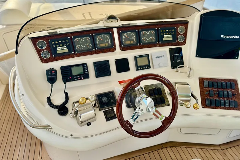 Scanner II Yacht Photos Pics 1998 Sea Ray 480 Sedan Bridge helm with gauges, controls, and Raymarine display.