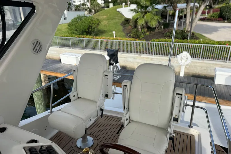 Scanner II Yacht Photos Pics 1998 Sea Ray 480 Sedan Bridge helm with white captain chairs and wooden deck.