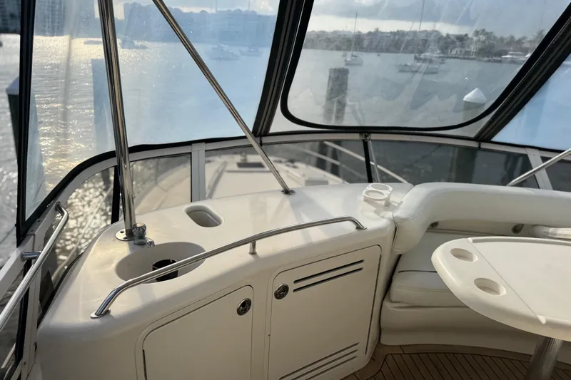 Scanner II Yacht Photos Pics 1998 Sea Ray 480 Sedan Bridge yacht interior with seating and table, overlooking marina.