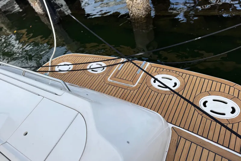 Scanner II Yacht Photos Pics 1998 Sea Ray 480 Sedan Bridge yacht deck with wood finish, docked by water.