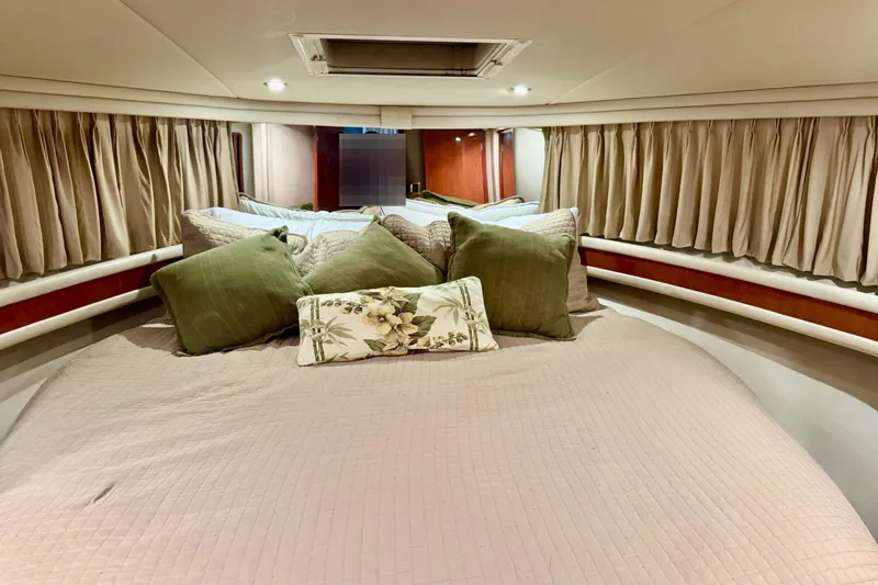 Scanner II Yacht Photos Pics Cozy bedroom interior of 1998 Sea Ray 480 Sedan Bridge with elegant bedding and curtains.