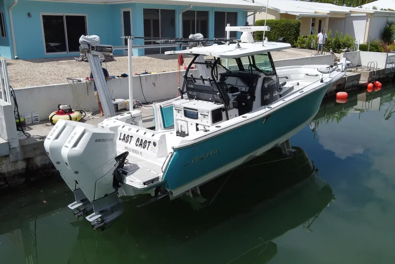  Yacht Photos Pics 2024 Blackfin 332 CC boat docked, featuring twin Mercury engines and modern design.