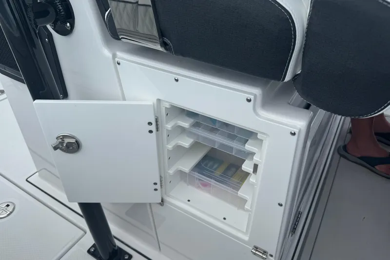  Yacht Photos Pics 2024 Blackfin 332 CC boat storage compartment with open door and organized shelves.