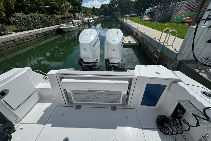  Yacht Photos Pics 2024 Blackfin 332 CC boat with twin Mercury engines docked in a canal.