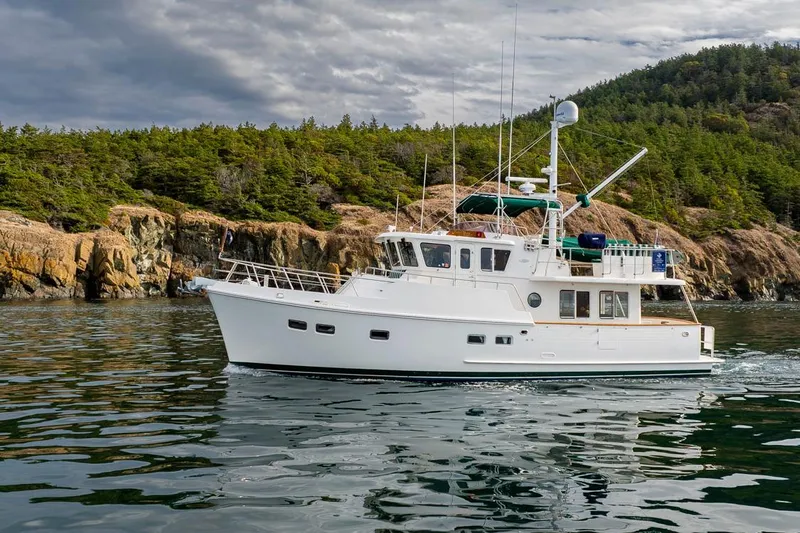 Forever Young Yacht Photos Pics Selene 43 yacht cruising near rocky coastline, 2009 model, under cloudy skies.