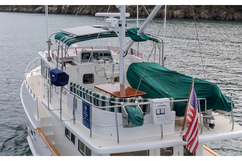 Forever Young Yacht Photos Pics 2009 Selene 43 yacht with green covers and American flag on calm water.
