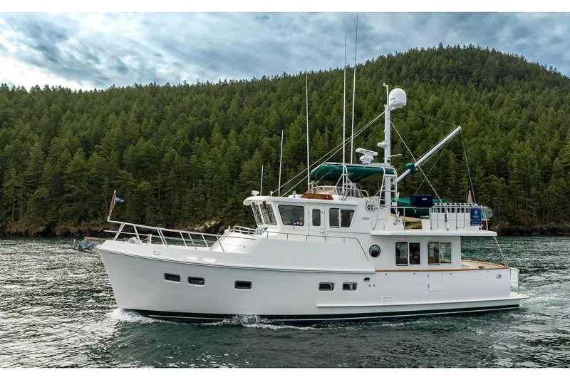 Forever Young Yacht Photos Pics 2009 Selene 43 yacht cruising on a scenic lake with forested hills in the background.