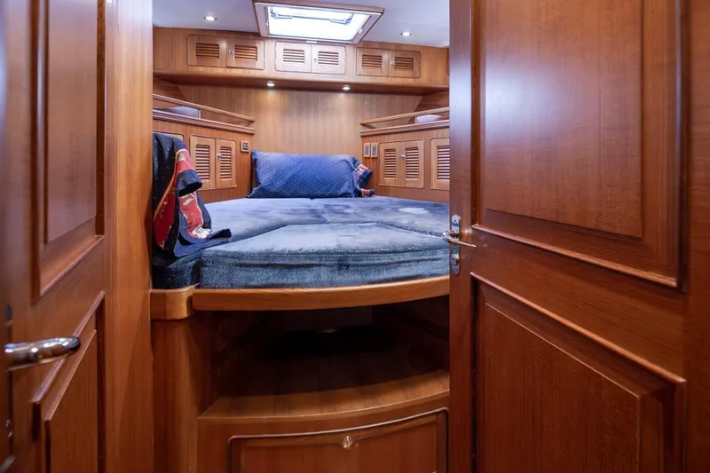 Forever Young Yacht Photos Pics Cozy cabin interior of 2009 Selene 43 yacht with wooden finish and comfortable bedding.