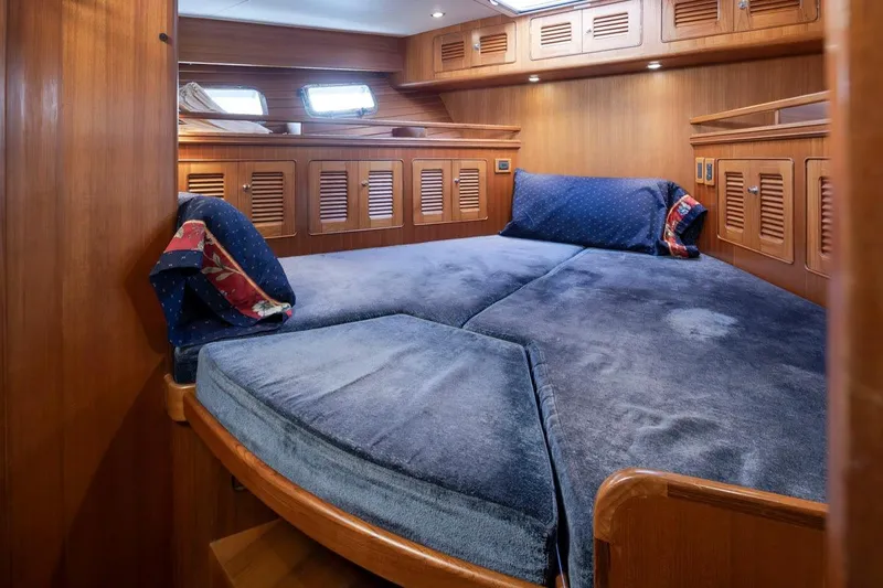 Forever Young Yacht Photos Pics Luxurious cabin interior of 2009 Selene 43 yacht with plush bedding and wooden cabinetry.