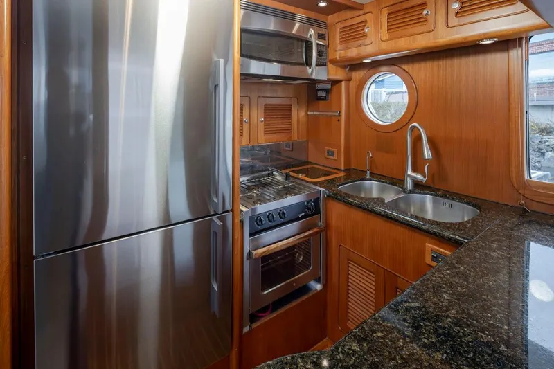 Forever Young Yacht Photos Pics Luxurious 2009 Selene 43 yacht kitchen with stainless steel appliances and elegant wood cabinetry.