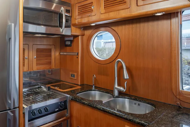 Forever Young Yacht Photos Pics Luxurious 2009 Selene 43 yacht kitchen with stainless steel appliances and porthole window.