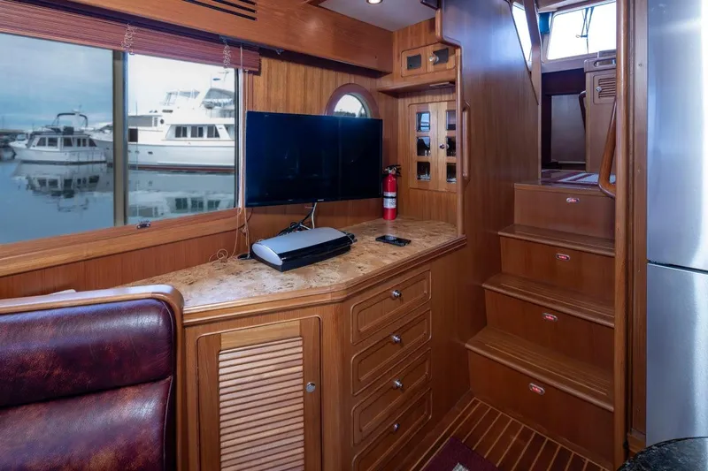 Forever Young Yacht Photos Pics Luxurious 2009 Selene 43 yacht interior with wood cabinetry, TV, and marina view.