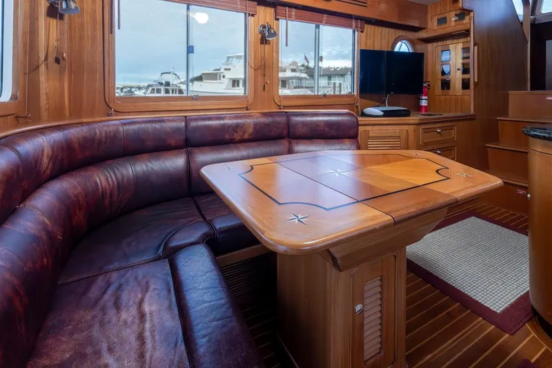 Forever Young Yacht Photos Pics Luxurious 2009 Selene 43 yacht interior with leather seating and wooden dining table.