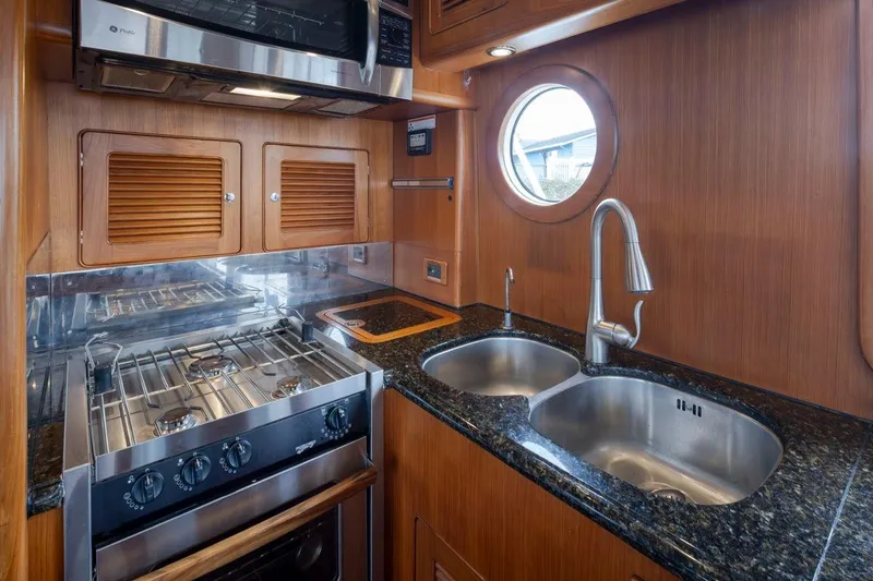 Forever Young Yacht Photos Pics Luxurious 2009 Selene 43 yacht kitchen with granite countertops and stainless steel appliances.