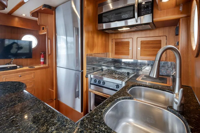 Forever Young Yacht Photos Pics Luxurious 2009 Selene 43 yacht kitchen with modern appliances and elegant wood finish.