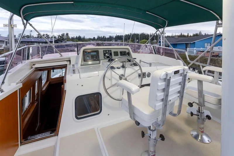Forever Young Yacht Photos Pics 2009 Selene 43 yacht helm with dual white captain chairs and green canopy.
