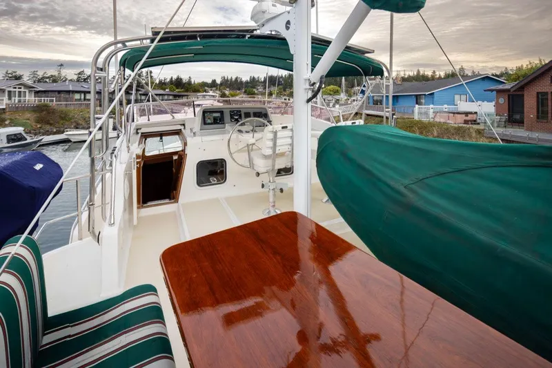 Forever Young Yacht Photos Pics 2009 Selene 43 yacht deck with polished wood table and green canopy.