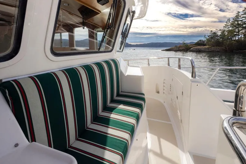 Forever Young Yacht Photos Pics 2009 Selene 43 yacht with striped seating, scenic water view, and clear skies.