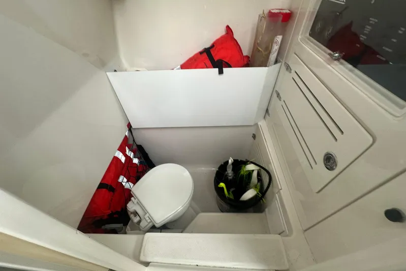 Warden Pass Too Yacht Photos Pics Interior of 2013 Jupiter 30 Center Console boat with life jackets and toilet.
