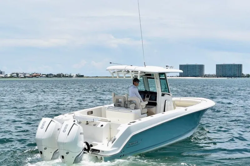  Yacht Photos Pics 2023 Boston Whaler 280 Outrage boat cruising on open water with cityscape background.