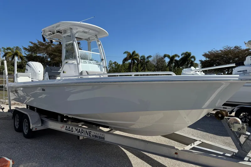  Yacht Photos Pics 2024 Everglades 243 Center Console boat on trailer, parked outdoors under clear sky.
