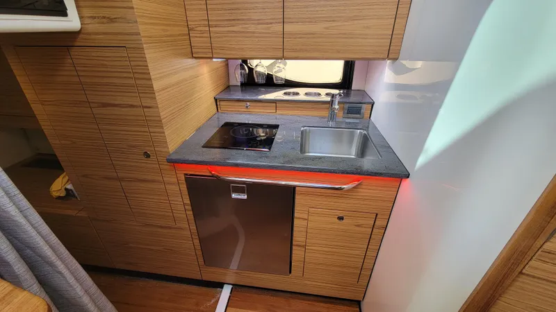  Yacht Photos Pics 2021 Boston Whaler 405 Conquest kitchen with modern appliances and wood cabinetry.