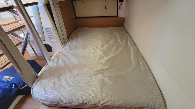  Yacht Photos Pics 2021 Boston Whaler 405 Conquest cabin with a cozy bed and wooden accents.