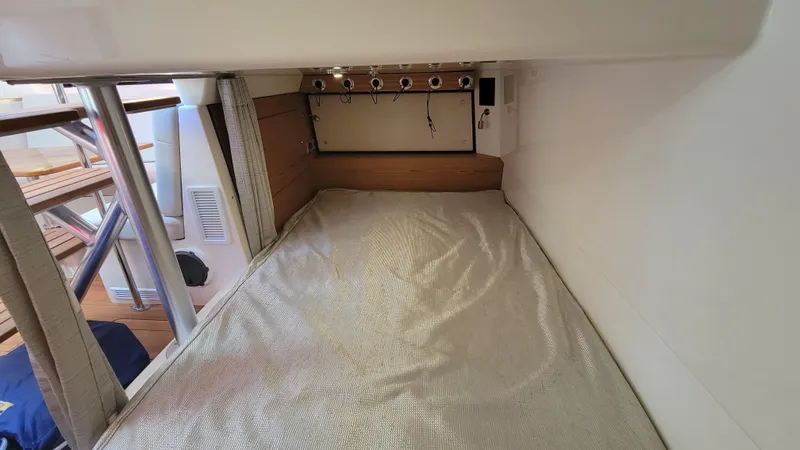  Yacht Photos Pics 2021 Boston Whaler 405 Conquest cabin interior with bed and fishing rod holders.