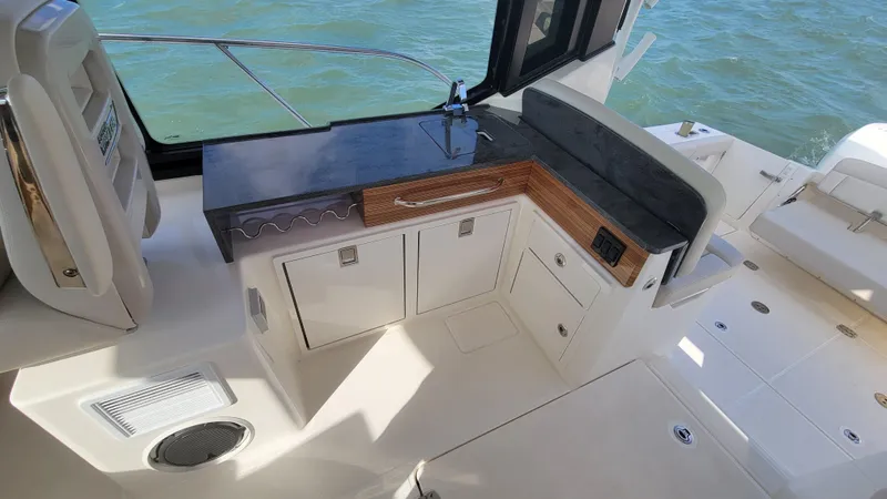  Yacht Photos Pics 2021 Boston Whaler 405 Conquest boat interior with kitchenette and seating area.