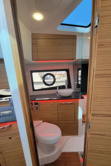  Yacht Photos Pics Interior of 2021 Boston Whaler 405 Conquest boat bathroom with wood cabinetry and modern fixtures.