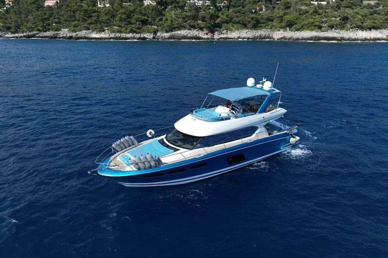 Grace Yacht Photos Pics Luxury 2013 Prestige 620 yacht cruising on blue ocean near rocky coastline.