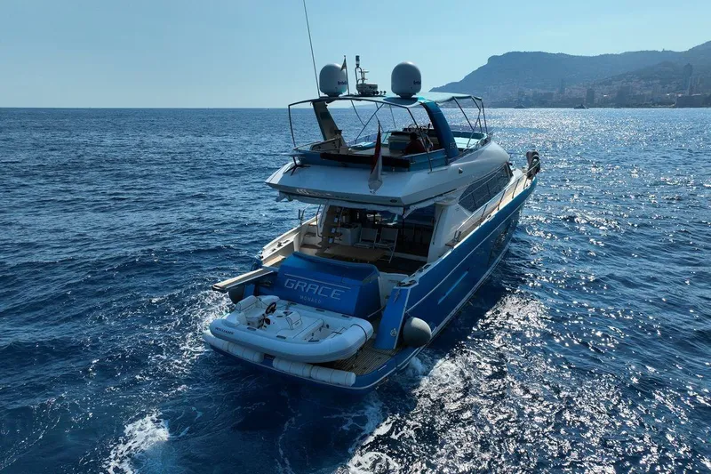 Grace Yacht Photos Pics Prestige 620 yacht cruising on open sea, 2013 model, with scenic coastal backdrop.