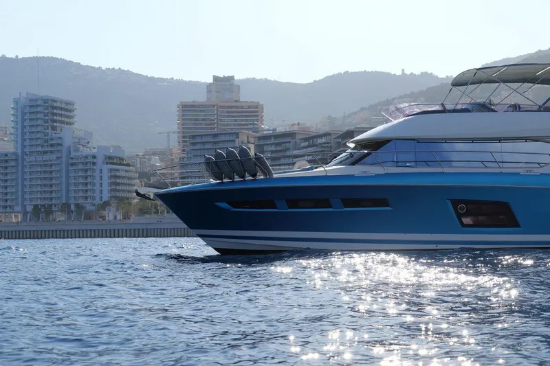 Grace Yacht Photos Pics Luxurious 2013 Prestige 620 yacht cruising near urban skyline, reflecting sunlight on water.