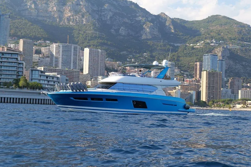 Grace Yacht Photos Pics Luxury 2013 Prestige 620 yacht cruising near coastal cityscape and mountains.