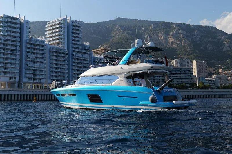 Grace Yacht Photos Pics Luxury 2013 Prestige 620 yacht cruising near modern waterfront buildings.