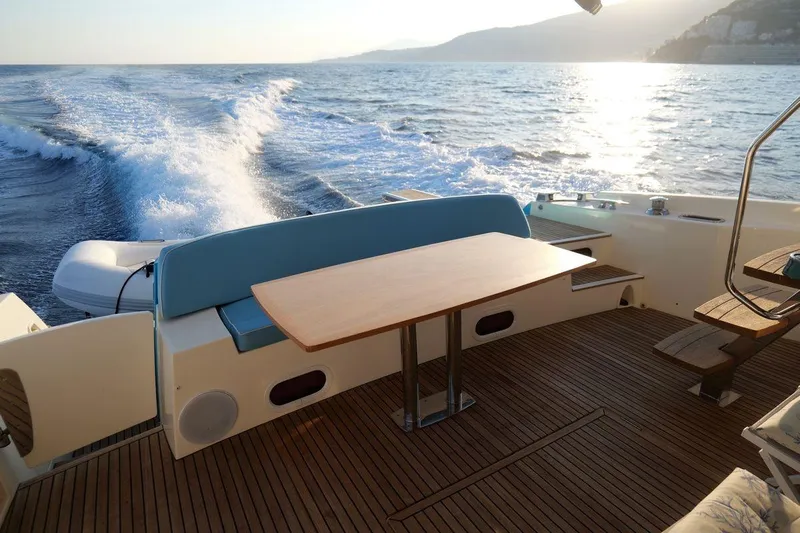 Grace Yacht Photos Pics Prestige 620 yacht deck with table, ocean view, and sunset, 2013 model.