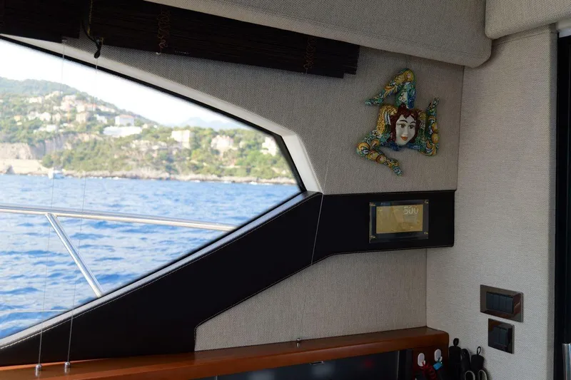 Grace Yacht Photos Pics Interior view of a 2013 Prestige 620 yacht with scenic ocean and coastal backdrop.